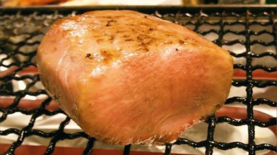 把牛肉放在炉子上烤，看着油脂慢慢溢出来