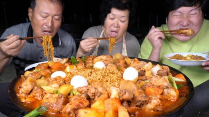 在辣炒鸡汤里放入大葱和泡面，再配上鸡蛋，满满一大盘美味极了！