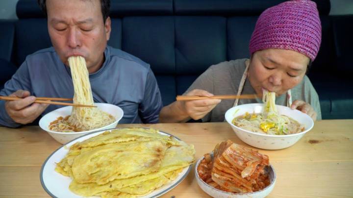 爸爸妈妈一起享用美味的纳帕白菜煎饼和热面条，健康的一餐！