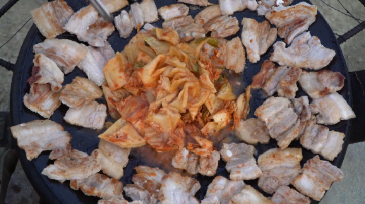 大锅煎烤五花肉和泡菜，泡菜的酸辣味和滋啦冒烟的肉香太开胃了！