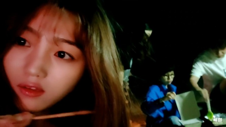 一群人在海边做烧烤吃，美女吃的好开心