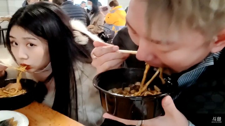 小王哥和美女一起吃面，美女吃的很香啊，小王哥都吃完了