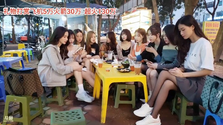 一群美女在户外坐着聊天，小心忙着玩手机啊