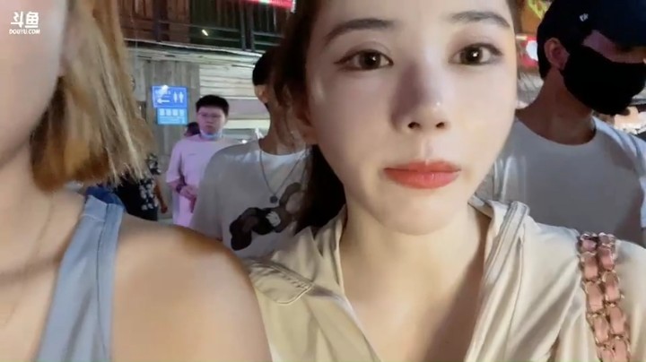 美女小姐姐在海口游玩，在街边看别人表演