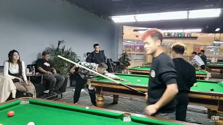 浩哥和美女阿狸打桌球，两个人旗鼓相当，不分伯仲，最后的黑球打了很久