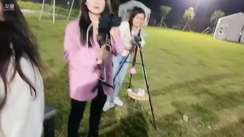 肖哥让人示范套圈圈游戏，人坐着那里套