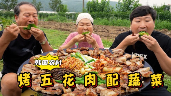 全家享用烤五花肉配着泡菜和新鲜蔬菜，清香和肉香混合，太赞了！